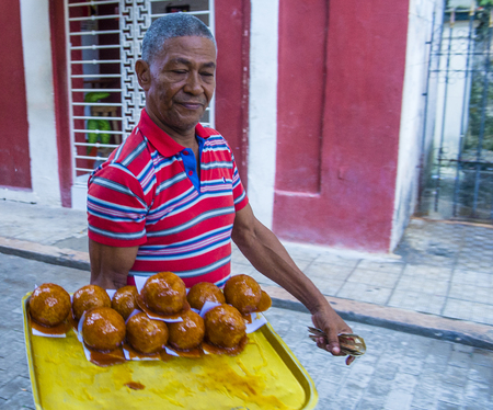 HAVANA, CUBA - JULY 18 : A Cuban man selling donuts in old Havana street on July 18 2016. The historic center of Havana is UNESCO World Heritage Site since 1982.のeditorial素材