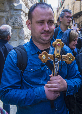 JERUSALEM - APRIL 14 : Christian pilgrim carry across along the Via Dolorosa in Jerusalem on April 14 2017 commemorating the path Jesus carried his cross on the day of his crucifixionのeditorial素材