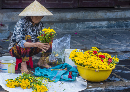 HOI AN , VIETNAM  - OCT 05 : Vietnamese woman selling flowers in a market in Hoi An Vietnam on October 05 2017. Agriculture is the main industry in Vietnamのeditorial素材