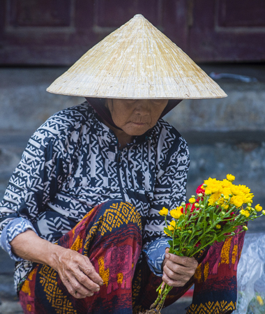 HOI AN , VIETNAM  - OCT 05 : Vietnamese woman selling flowers in a market in Hoi An Vietnam on October 05 2017. Agriculture is the main industry in Vietnamのeditorial素材