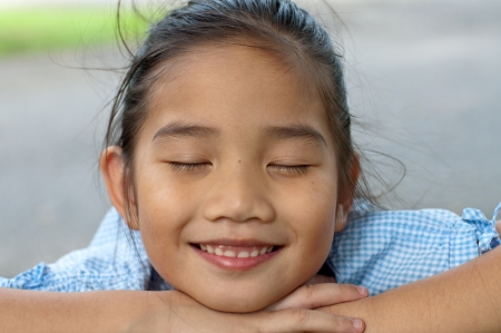 Head shot portrait of beautiful little asian girl in the park, Thailand.の写真素材