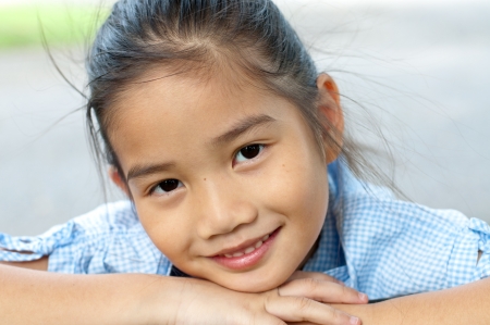 Head shot portrait of beautiful little asian girl in the park, Thailand.の写真素材