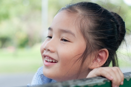 Head shot portrait of beautiful little asian girl in the park, Thailand.の写真素材