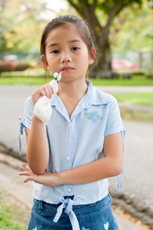 Portrait of beautiful little asian girl in the park, she is thinking, Thailand.の写真素材