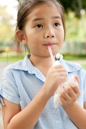 Head shot portrait of beautiful little asian girl in the park, she is thinking, Thailand.の写真素材