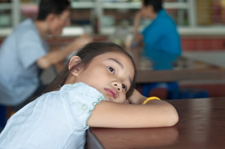 Beautiful asian girl waits parent at  restaurant, Thailand.の写真素材