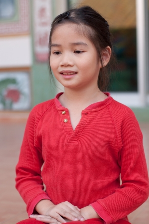 Beautiful asian girl in red suit at Chinese temple, Thailand.の写真素材