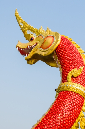 Red Naga statue on blue sky, Thailandの写真素材