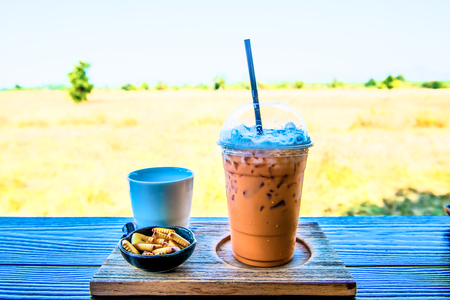 Iced Milk Tea with biscuit on Wooden Table, Thailandの写真素材