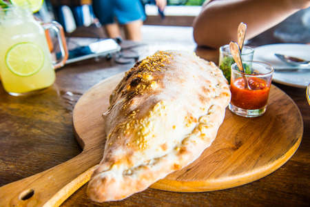 Pizza puff on wooden plate, Thailand.の写真素材