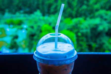 Iced coffee in plastic glass on the table, Thailand.の写真素材