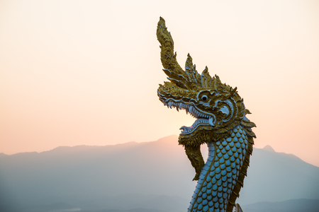 White Naga statue at Kwan Phayao with evening sun, Thailand.の写真素材