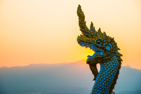 White Naga statue at Kwan Phayao with evening sun, Thailand.の写真素材