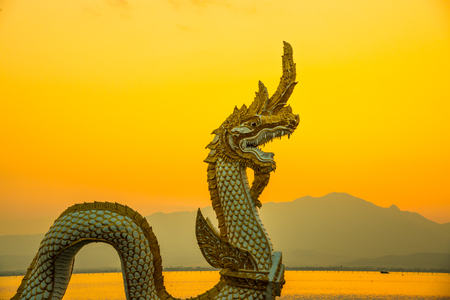 White Naga statue at Kwan Phayao with evening sun, Thailand.の写真素材