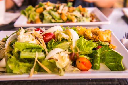 Mixed vegatable salad with honey lemon dressing, poached egg and bacon at Thailandの写真素材