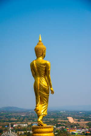 Walking golden buddha statue at Phra That Khao Noi temple, Thailand.の写真素材