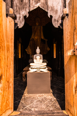 White buddha with wooden door frame, Thailand.の写真素材