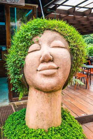 Ceramic doll with grass on head, Thailand.の写真素材