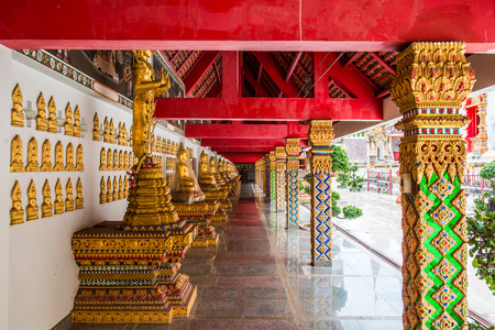 Corridor with buddha statue around pagoda at Phra That Suthon Mongkhon Khiri temple, Thailand.の写真素材
