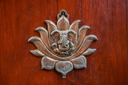 Metal Ganesha on wood panel, Thailand.の写真素材