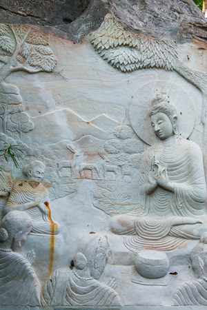 Carving Buddha art on rock in Huai Pha Kiang temple, Thailand.の写真素材