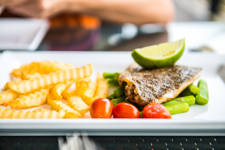 Fish steak on white plate, Thailand.の写真素材
