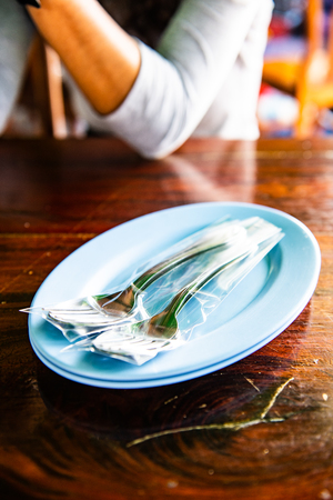 fork and spoon in plastic bag on plate, Thailand.の写真素材