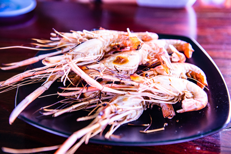 Grilled prawns on black plate, Thailand.の写真素材