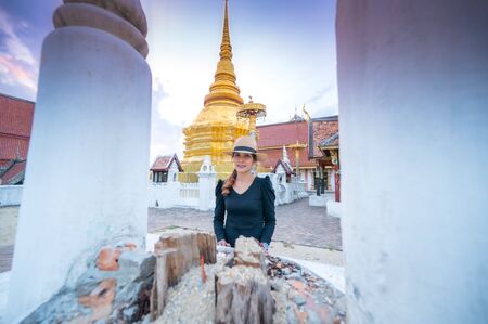 Asian woman with Wat Pong Sanuk background, Lampang province.