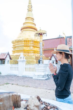 Asian woman with Wat Pong Sanuk background, Lampang province.