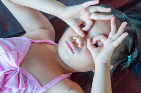 Asian little girl in pink dress is playing, Thailand.