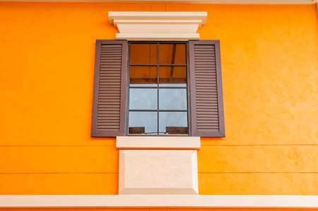 Vintage window with orange wall, Thailand.の写真素材