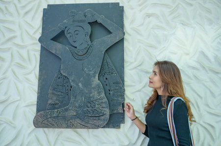 A woman in black with art on the wall