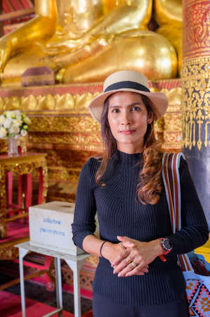 Asian Woman in Black Dress with Wat Phumin Background, Nan Province.の写真素材