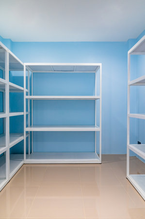 Empty white shelves in blue storage room, Thailand.の写真素材