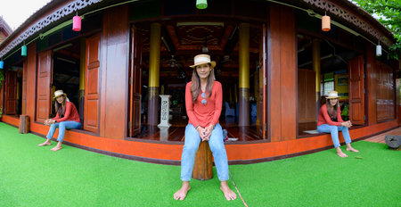 Pamorama of triple Asian female tourists with old wooden building background at Phayao province,...