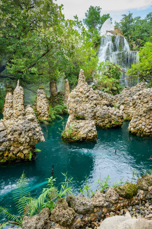 Small waterfall and green pond in shady garden, Chiang Mai province.の写真素材