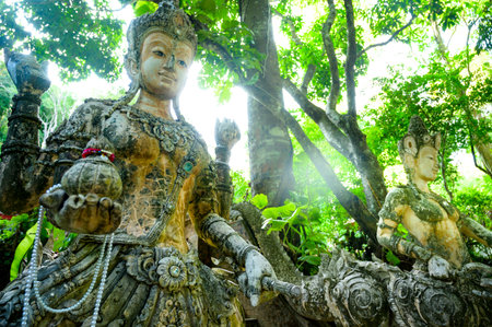 Ancient statue covered with moss in Wat Pha Lat, Thailand.
