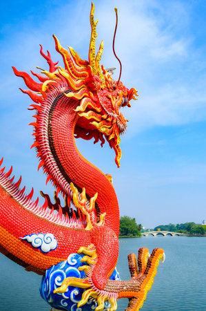 Red dragon statue and lake view in Nakhon Sawan Province, Thailand.の写真素材