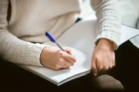 Female hands holding a pen and notebook