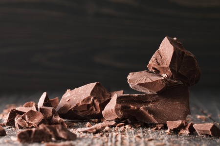 Handmade chocolate pieces on a dark wooden backroundの写真素材
