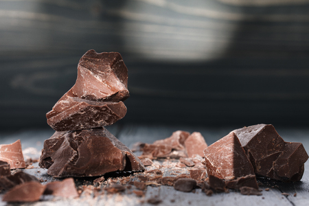 Handmade chocolate pieces in a spotlight on a dark wooden backroundの写真素材