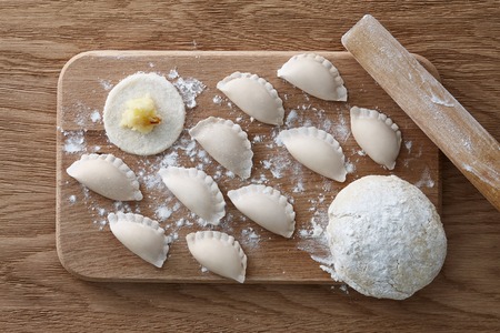 Traditional Ukrainian dumplings (varenyky or pierogi) with mashed potatoes and onion preparation process. Top view.の写真素材