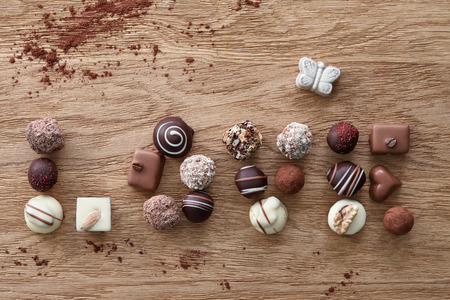 Word love composed of chocolate candies on a wooden background. Top view.