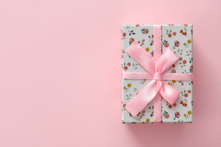 Cute floral pattern gift box on a pink background, space for textingの写真素材