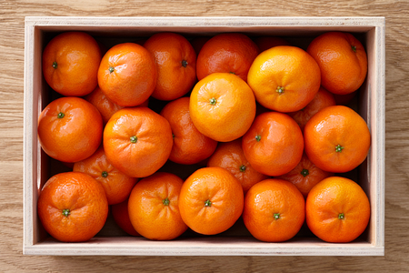 Fresh mandarines box on a wooden backgroundの写真素材