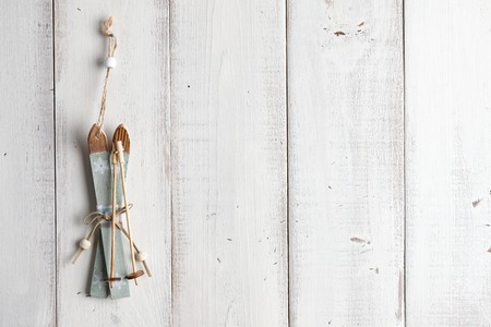 Wooden toy ski christmas decoration hanging over white fence