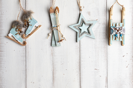 Wooden christmas decorations hanging over white fenceの写真素材