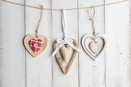 Wooden valentine hearts hanging over white fenceの写真素材