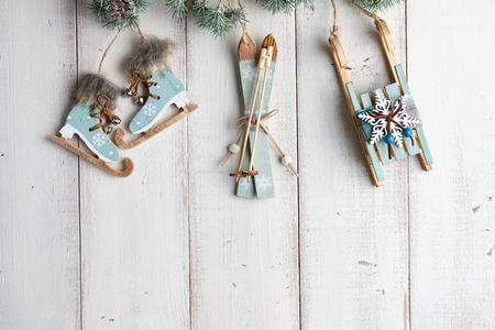 Wooden christmas decorations hanging over white fence on a fir treeの写真素材